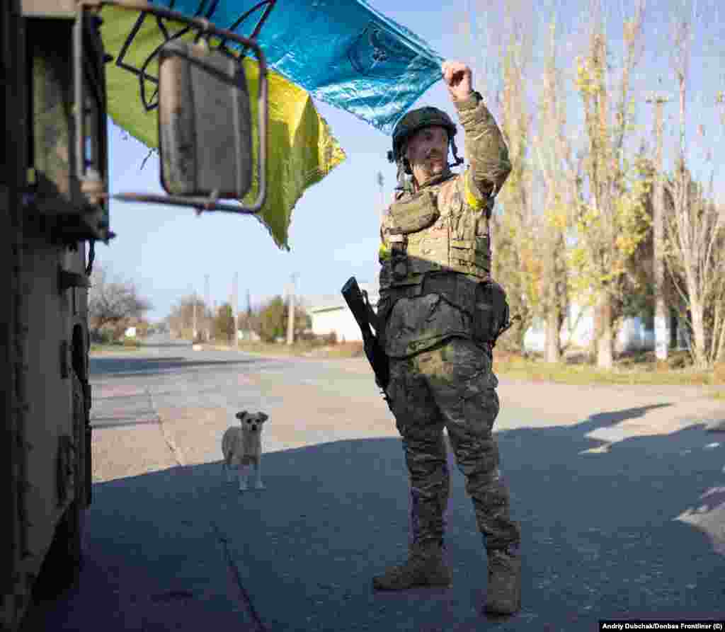 Солдат показує збережений у боях прапор України, чиї кольори виблискують під промінням сонця, яке вже починає сідати над звільненою від російських окупантів Снігурівкою.&nbsp;&nbsp; Місто, розташоване на стратегічній висоті на самому півдні Миколаївщини і за 50 кілометрів від Херсона, було окупованим з початку березня 2022 року