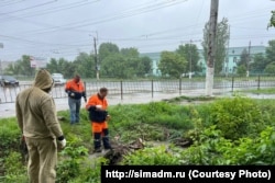 Коммунальные службы Симферополя расчищают улицы города от упавших деревьев во время осадков, 31 мая 2023 года