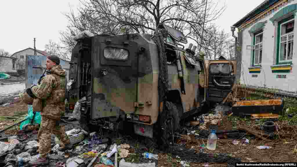 Орыс әскері тастап кеткен бронтранспортер жанында тұрған украин сарбазы.