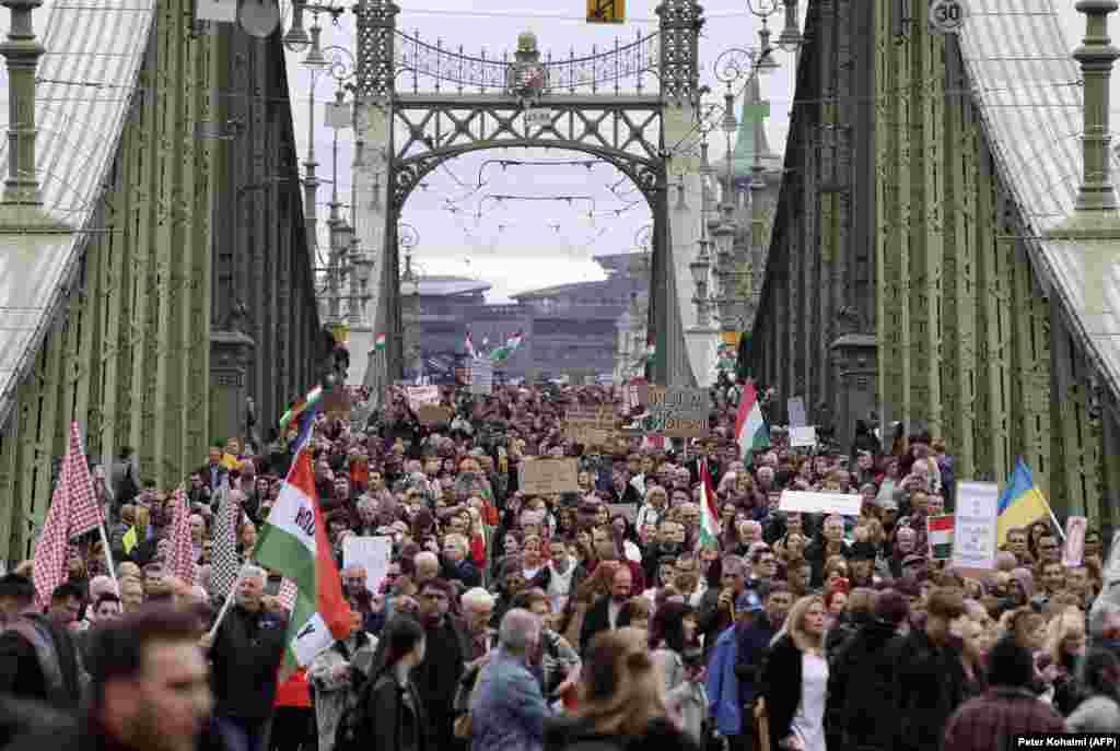 Протестующие идут по мосту Свободы в Будапеште, 23 октября. Многотысячная толпа стала одним из крупнейших протестов, с которыми сталкивалось пропунинское правительство Виктора Орбана. Протестующие объединились по целому ряду вопросов, включая условия для учителей и тяжелую экономическую ситуацию в Венгрии.