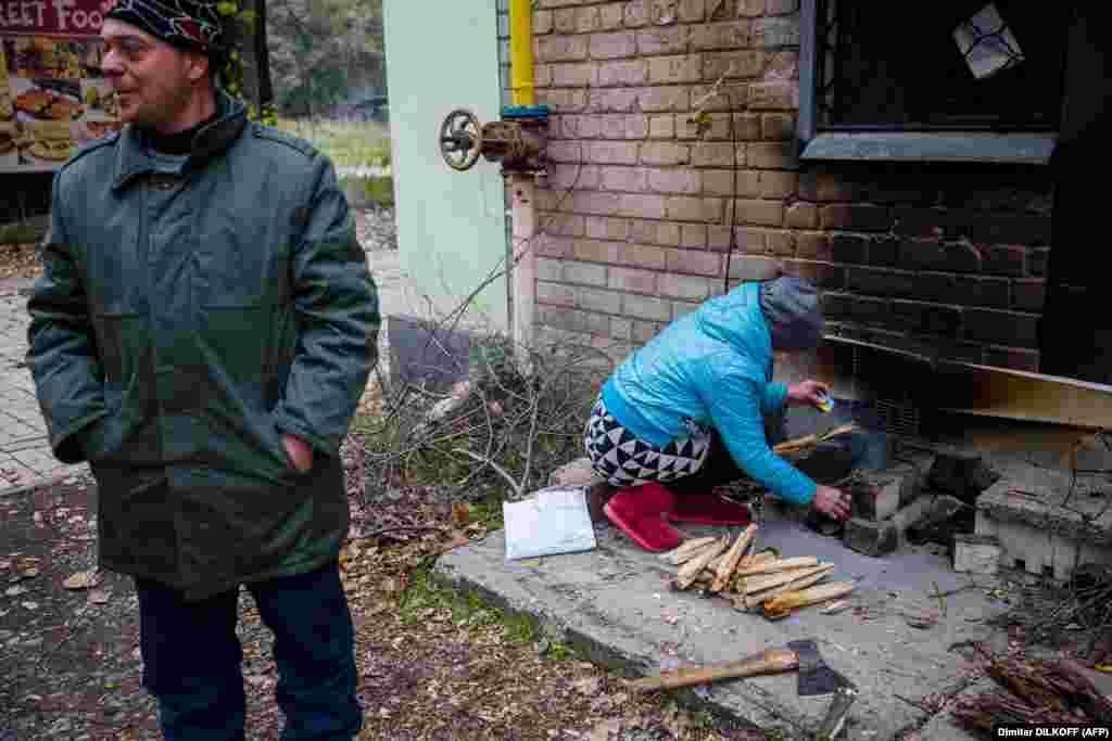 Жінка розводить вогнище для приготування їжі