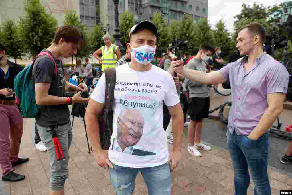 Протестующий в майке с фото постаревшего Владимира Путина в Москве. Поправки позволят Путину оставаться президентом России до 2036 года