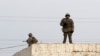 Kazakhstan - In this photo taken Saturday, Dec. 17, 2011, armed Kazakh soldiers stand on a top of a building in center of Zhanaozen, Kazakhstan. Kazakhstan President Nursultan Nazarbayev on Saturday imposed a three-week state of emergency in an oil town w