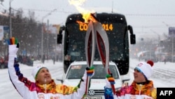 Arxiv foto: Soçi Olimpiadasının təşkilat komitəsi üzvləri Ufa regionundan keçərkən Olimpiya məşəllərini "öpüşdürürlər". 21 dekabr 2013