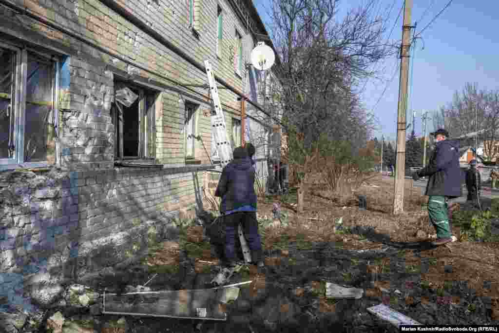 Рабочие приехали на замену окон, разбитых артиллерийским снарядом в Новолуганском. Город расположен недалеко от линии разграничения, отделяющей позиции ВСУ от российских гибридных войск