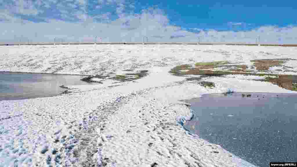 У самой плотины в результате обмеления от главной чаши водоема (слева) отделилось озерцо, которое полностью замерзло