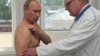 Russia -- Vladimir Putin (L) receives consultation from traumatologist Viktor Petrachenkov during his visit to Smolensk Regional Hospital, 25Aug2011