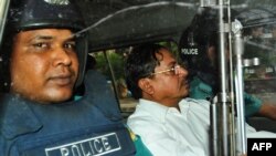 Mohammad Kamaruzzaman (ağ köynəkdə) Dəkkə məhkəməsini tərk edərkən.