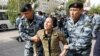 KAZAKHSTAN -- Kazakh law enforcement officers detain a woman during a rally held by opposition supporters in Nur-Sultan, September 21, 2019